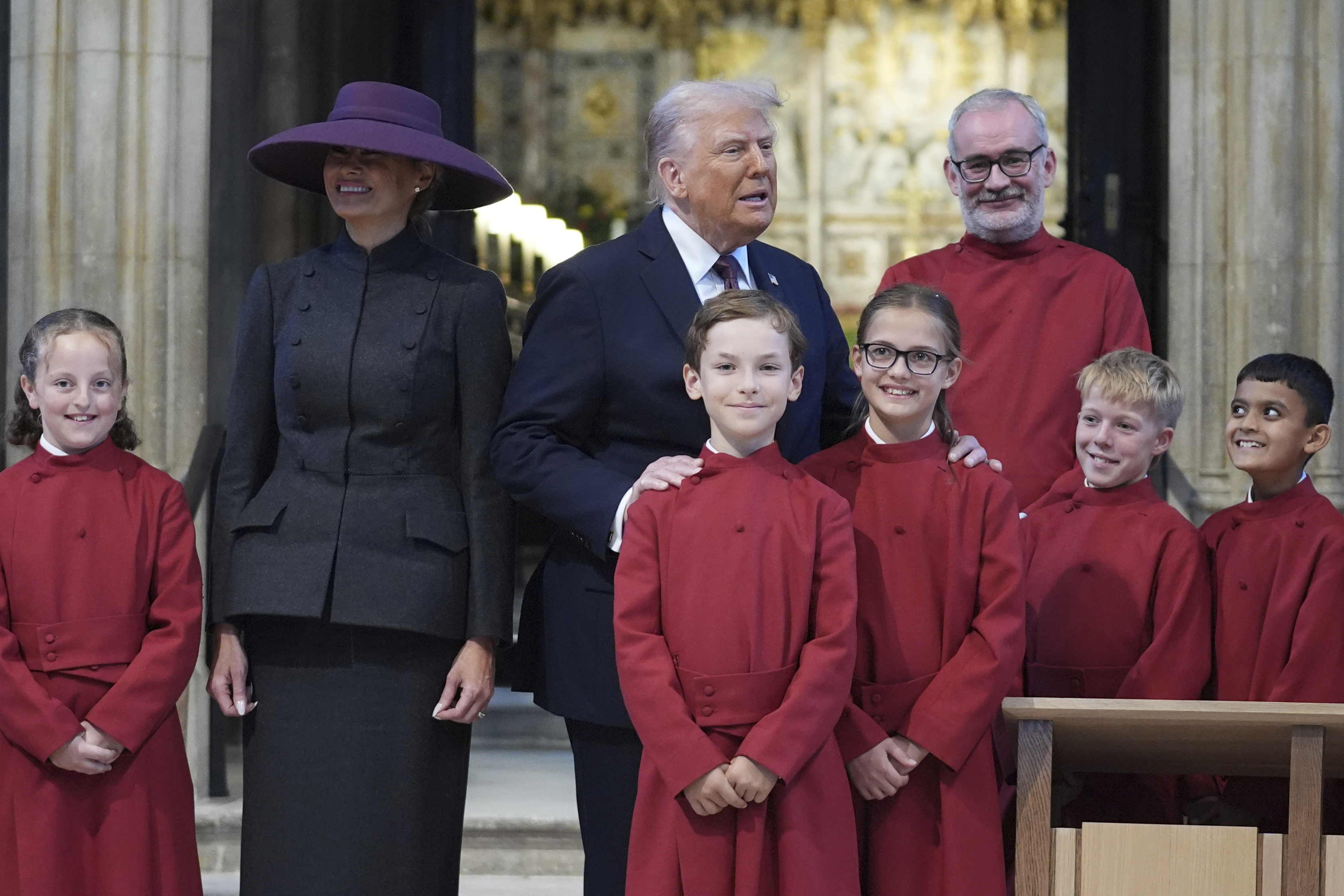 President Donald Trump and First Lady Melania Trump pose with a chorus of children while receiving a tour of the Chapel of San Giorgio at the Castle of Windsor (LaPresse)