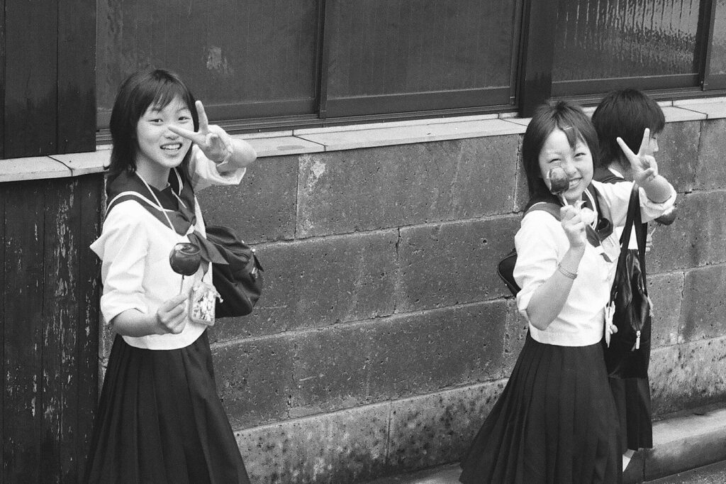 Why do Japanese people make the V (or peace) finger sign in photos?